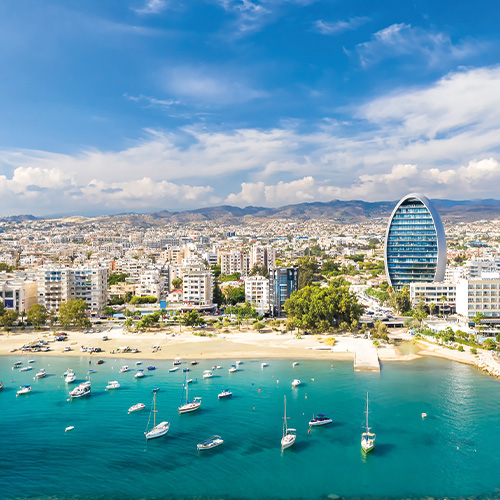 An aerial view of Limassol Cyprus showing the coastline, marina, and cityscape with a modern high-rise building