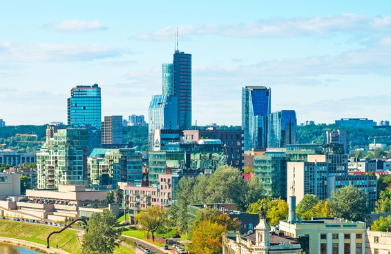 Vilnius, Lithuania skyline with modern buildings and green urban areas.